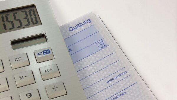 A calculator lying on a pile of receipts and bills