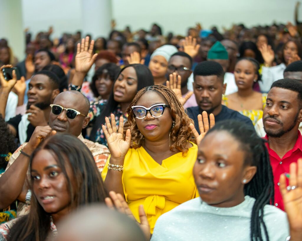 A group of people raising their hands during a church gathering