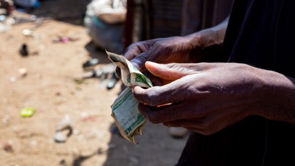 Close-up of hands counting Nigerian naira notes outdoors