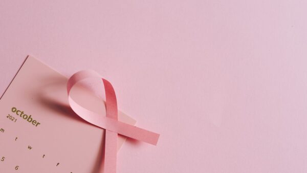 A pink breast cancer awareness ribbon on an October calendar page