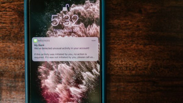 A smartphone on a wooden table showing a bank alert notification