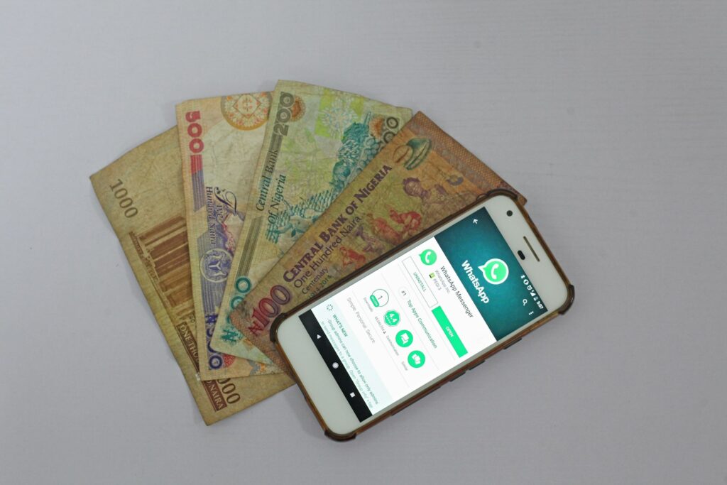 A white Android smartphone lying beside banknotes