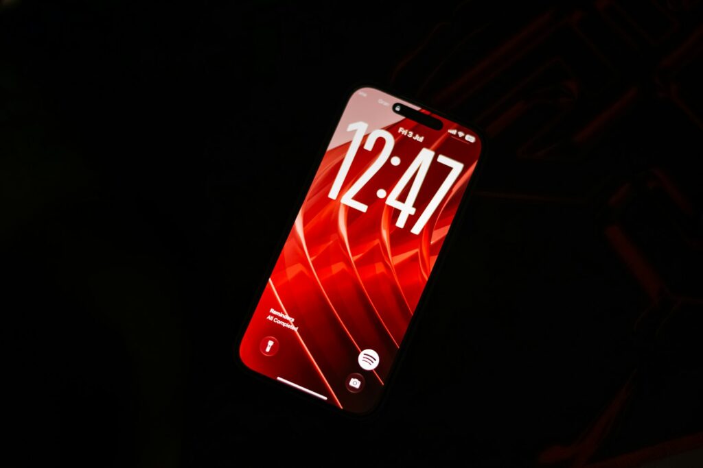 A smartphone with a red screen showing the time 12:47