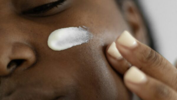 A woman putting lotion on her face