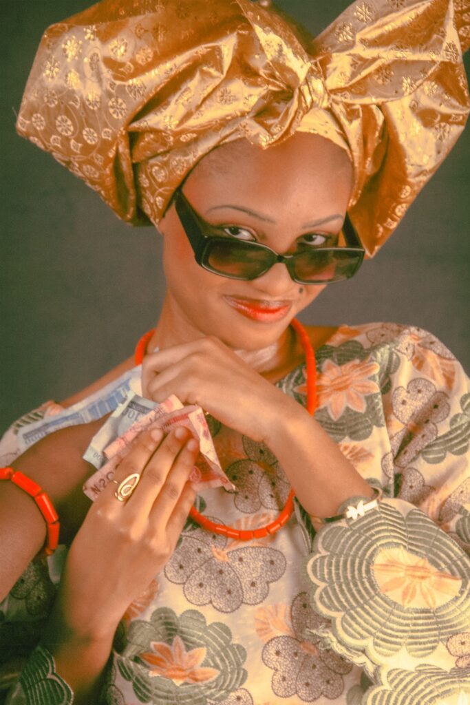 A woman in colourful traditional attire holding banknotes